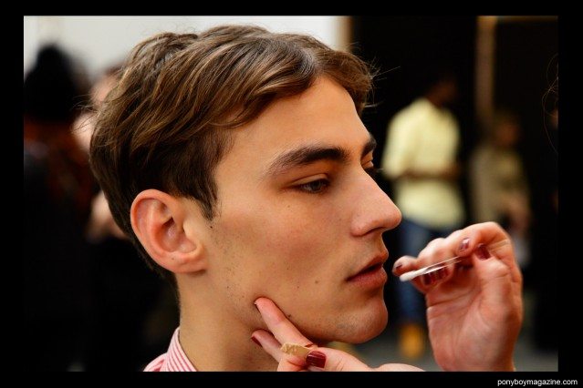 Male model Max Esken having his makeup applied backstage at Duckie Brown F/W15 collection at Industria Studios. Photographed by Alexander Thompson for Ponyboy magazine.