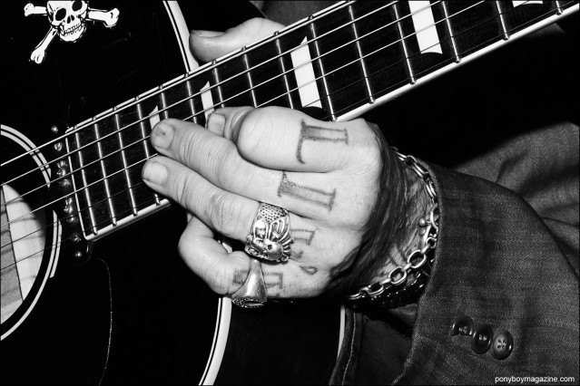 Detail shot of guitarist/singer Almon Loos tattooed hand, photographed onstage at rockabilly weekender Hula Rock Vol 2. Photograph by Alexander Thompson for Ponyboy magazine.