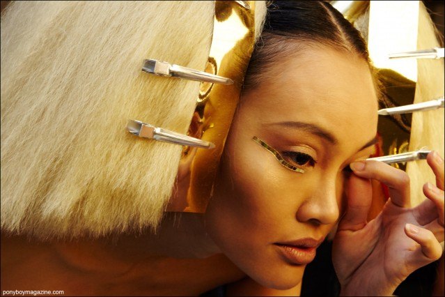 A model backstage adjusts her false eyelash, photographed at the Blonds S/S16 show by Alexander Thompson for Ponyboy magazine.
