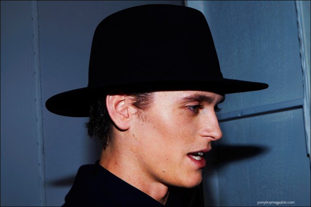 Male model Anders Hayward snapped backstage in a wide brimmed hat at Carlos Campos F/W16 menswear show by Alexander Thompson, for Ponyboy magazine.
