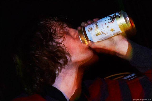 Musician Mike Brandon snapped onstage drinking a beer by Alexander Thompson for Ponyboy magazine.