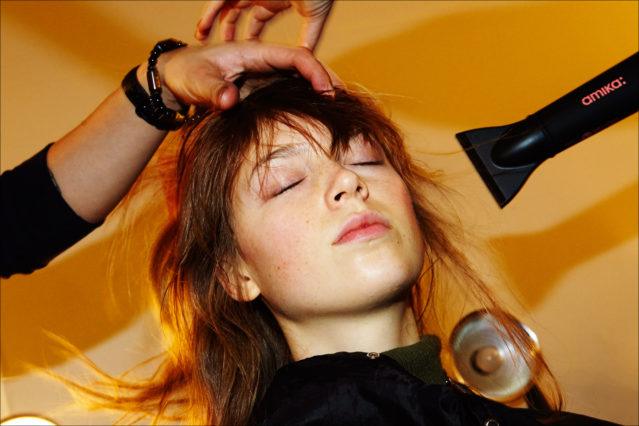 A model gets a blowout backstage at the Adam Selman Fall 2017 womenswear show in New York City. Photography by Alexander Thompson for Ponyboy magazine.