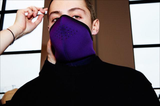 A model photographed in a purple face mask, backstage at Robert Geller A/W17 menswear show. Photography by Alexander Thompson for Ponyboy magazine NY.