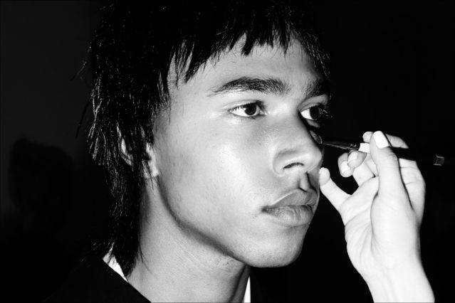 A male model has his makeup applied backstage at the Private Policy menswear show. Photography by Alexander Thompson for Ponyboy magazine.