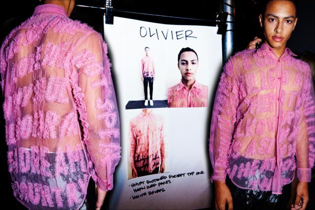 Male model Olivier photographed in a sheer shirt and pants, backstage at Libertine for Spring/Summer 2018. Photography by Alexander Thompson for Ponyboy magazine.