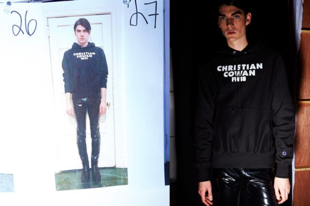 A male model wears a Christian Cowan sweatshirt and vinyl pants backstage for Fall 2018. Photography by Alexander Thompson for Ponyboy magazine.
