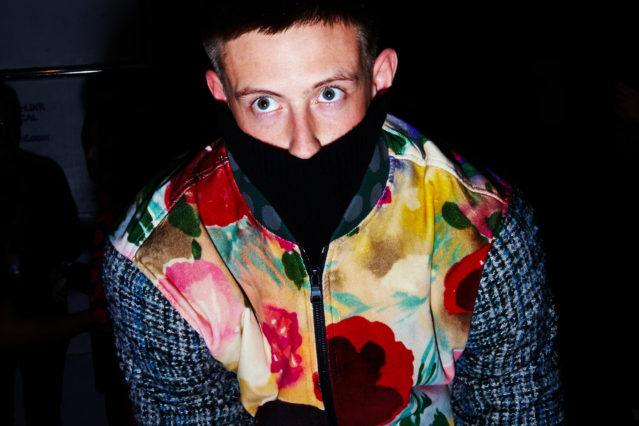 A male model snapped dressing backstage at Libertine for Fall 2018. Photography by Alexander Thompson for Ponyboy magazine.