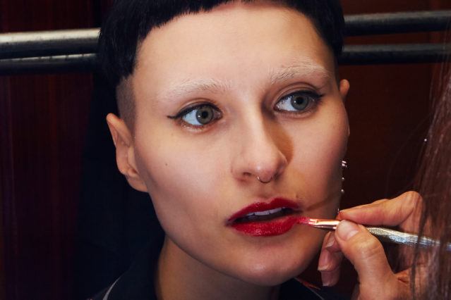 Close-up shot of a model getting makeup application at Snow Xue Gao Fall/Winter 2018. Photographed by Alexander Thompson for Ponyboy magazine.