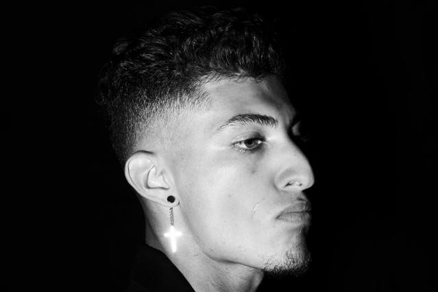 A male model with a gold cross earring snapped backstage at the Willy Chavarria S/S 2020 show. Photography by Alexander Thompson for Ponyboy magazine.